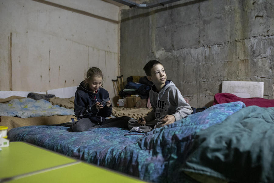 Alina and Artem, both 9, play with a phone in an underground car park now serving as a bomb shelter in the city of Kharkiv in northeastern Ukraine.