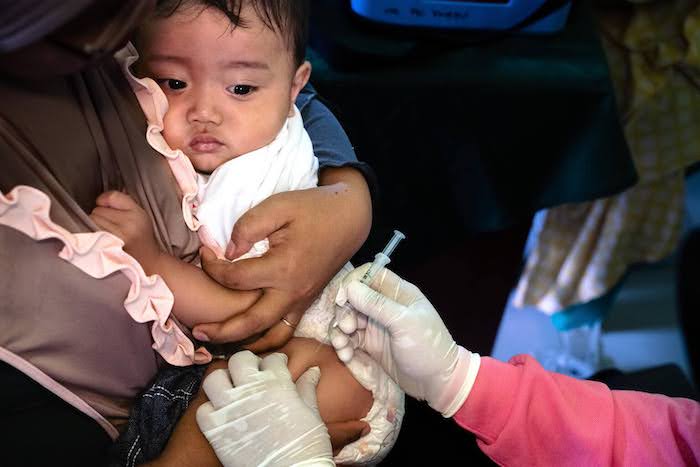 10-month-old Vito receives childhood immunizations at a village health clinic near Riau Islands Province, Indonesia, during a UNICEF-supported national vaccination campaign.