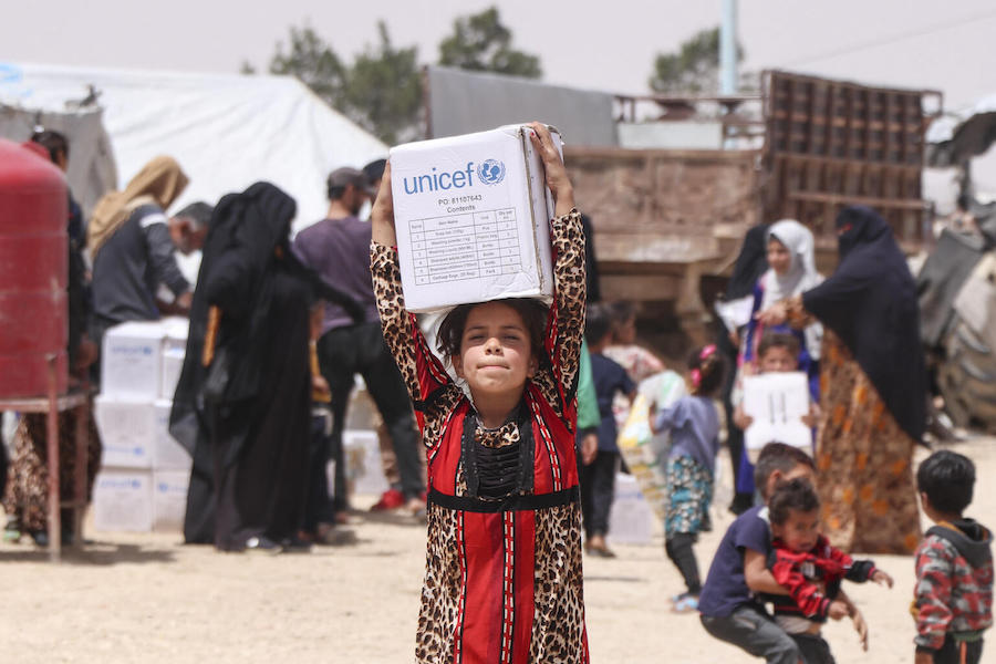 A child staying in Areesheh camp for displaced families in Hasakeh, northeast Syria, carries a box of hygiene supplies received from UNICEF on May 15, 2022.