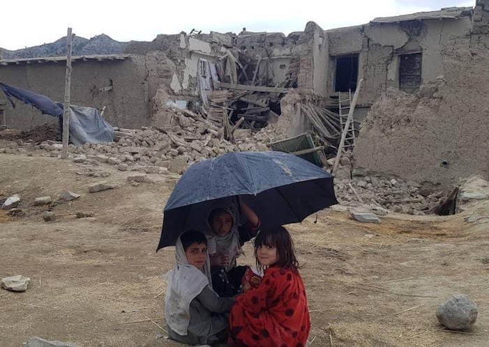 On June 23, 2022, children sit surrounded by the rubble of houses damaged by the earthquake in Gayan district, Paktika Province, Afghanistan.
