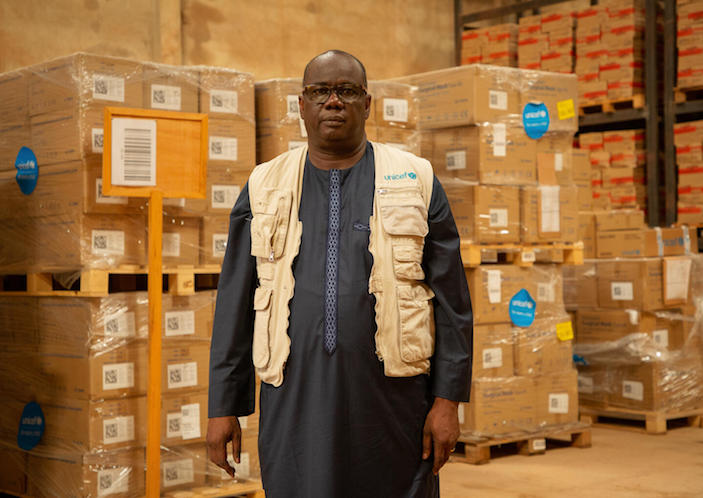 Amadou Tall, UNICEF Burkina Faso Supply and Logistics Manager, stands next to boxes of Ready-to-Use Therapeutic Food (RUTF) awaiting transportation in the UNICEF warehouse in Ouagadougou, Burkina Faso on June 24, 2022. 
