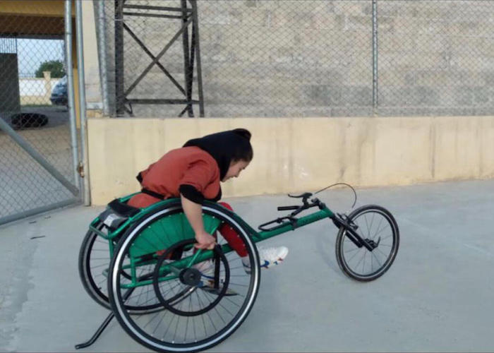 Fatima practices using her sports wheelchair, which she uses during basketball games.