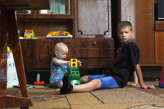One-year-old Makar plays with his elder 10-year-old brother Danylo. 