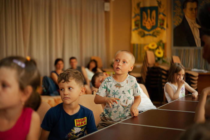 Children watching short cartoons about mine safety in Ukraine