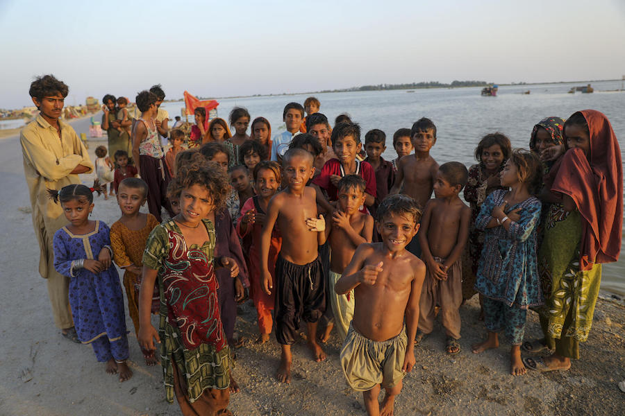 Children stand beside flood waters in Jacobabad district, Sindh Province, Pakistan, on Sept. 10, 2022. 
