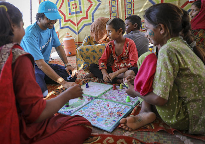 UNICEF Communication Officer Moeed Hussain plays board games with children at a Child-Friendly Space set up by UNICEF in the government-run campsite in Larkana district, Sindh Province, Pakistan.