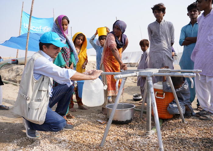 UNICEF WASH Officer Ihsan Ullah Khan fills a jug with safe drinking water at a collection point connected to a water bladder installed by UNICEF at a camp for flood-affected people in Khairpur district, Sindh Province, Pakistan.