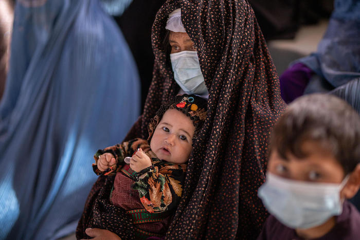 A child and caregiver in Badghis Province, Afghanistan, benefiting from UNICEF's cash transfer program aimed at reducing risks for children heightened by the country's economic crisis.