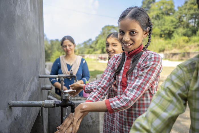 Eleven-year-old girl at a hand washing station at her middle school in India