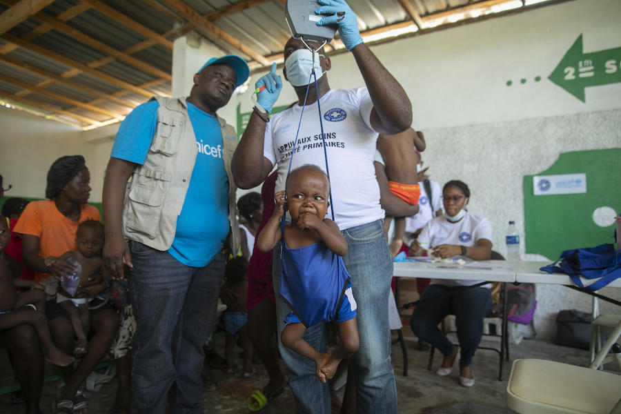 A 2-year-old boy cries as he is weighed at a malnutrition clinic run by UNICEF, in Cité Soleil, Haiti, on Oct. 16, 2022. 