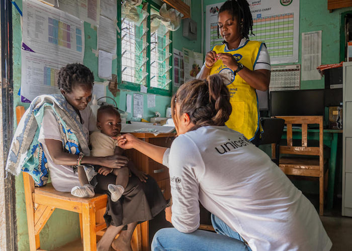 At Nadapal Health Facility in Turkana County, Kenya, UNICEF Goodwill Ambassador Priyanka Chopra Jonas says hello to 10-month-old Kevin as he sits on his mother's lap.