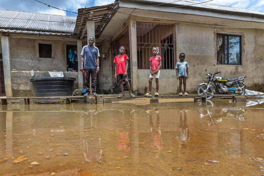Akpoebi Germany, far left, and his children rigged up a makeshift wooden walkway over the flooded yard outside their home in Sagbama, Bayelsa State, Nigeria.
