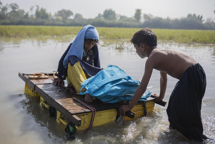 A girl and boy navigate contaminated floodwaters in Jacobabad district, Sindh Province, Pakistan.
