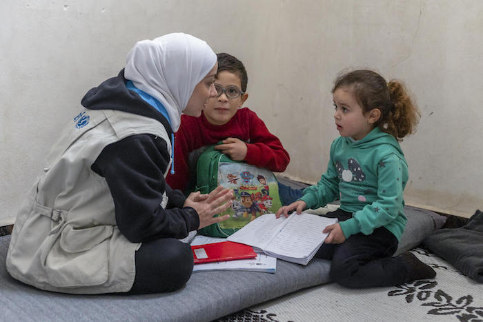 Yasmin Hulou of UNICEF visits with Radwan, 9, and his sister Rimas, 5, at their home in the Tal Az-Zarazir neighborhood of Aleppo, Syria, on Nov. 17, 2022. 