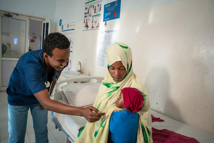 1-year-old Aisha, recovering from severe acute malnutrition at a UNICEF-supported stabilization center in Puntland, Somalia, is greeted by her doctor and held by her mother.