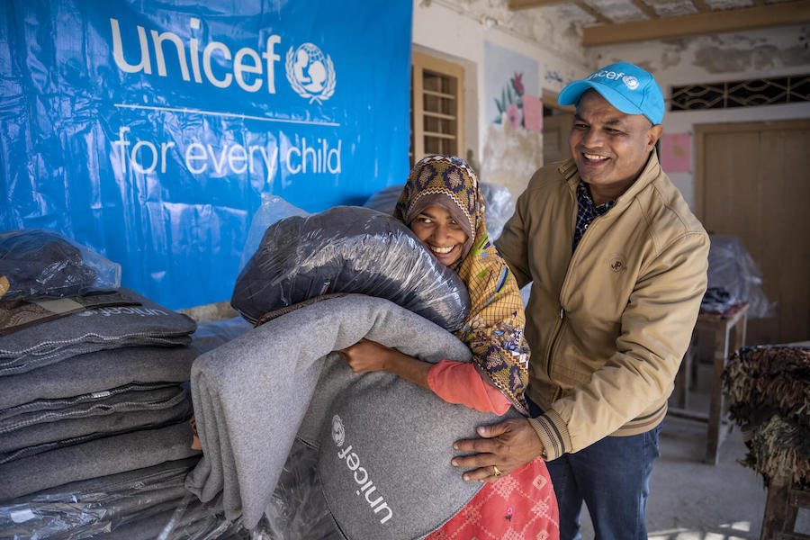 UNICEF's Chief of Field Office in Sindh - Prem Chand with 11-year-old Rahman who has just received a warm winter jacket and other items from UNICEF in Mitho Babbar Village, Dadu District, Sindh Province.