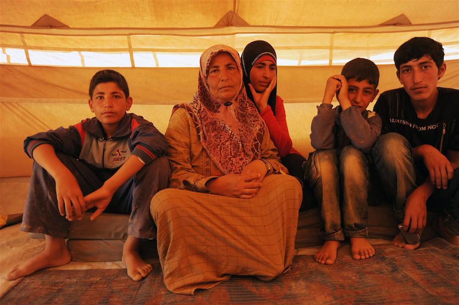 A woman sits with her children in Za’atari; with a population of over 80,000 people, it’s one of the largest refugee camps in the world.