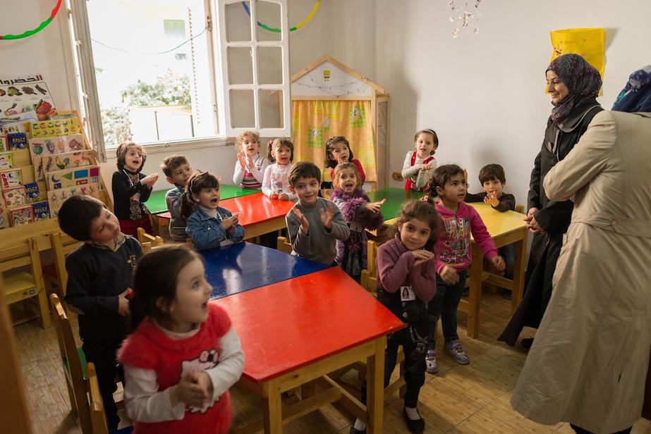 Children clap and sing during a music class in a UNICEF-supported kindergarten for Syrian refugee children, in the city of Giza.