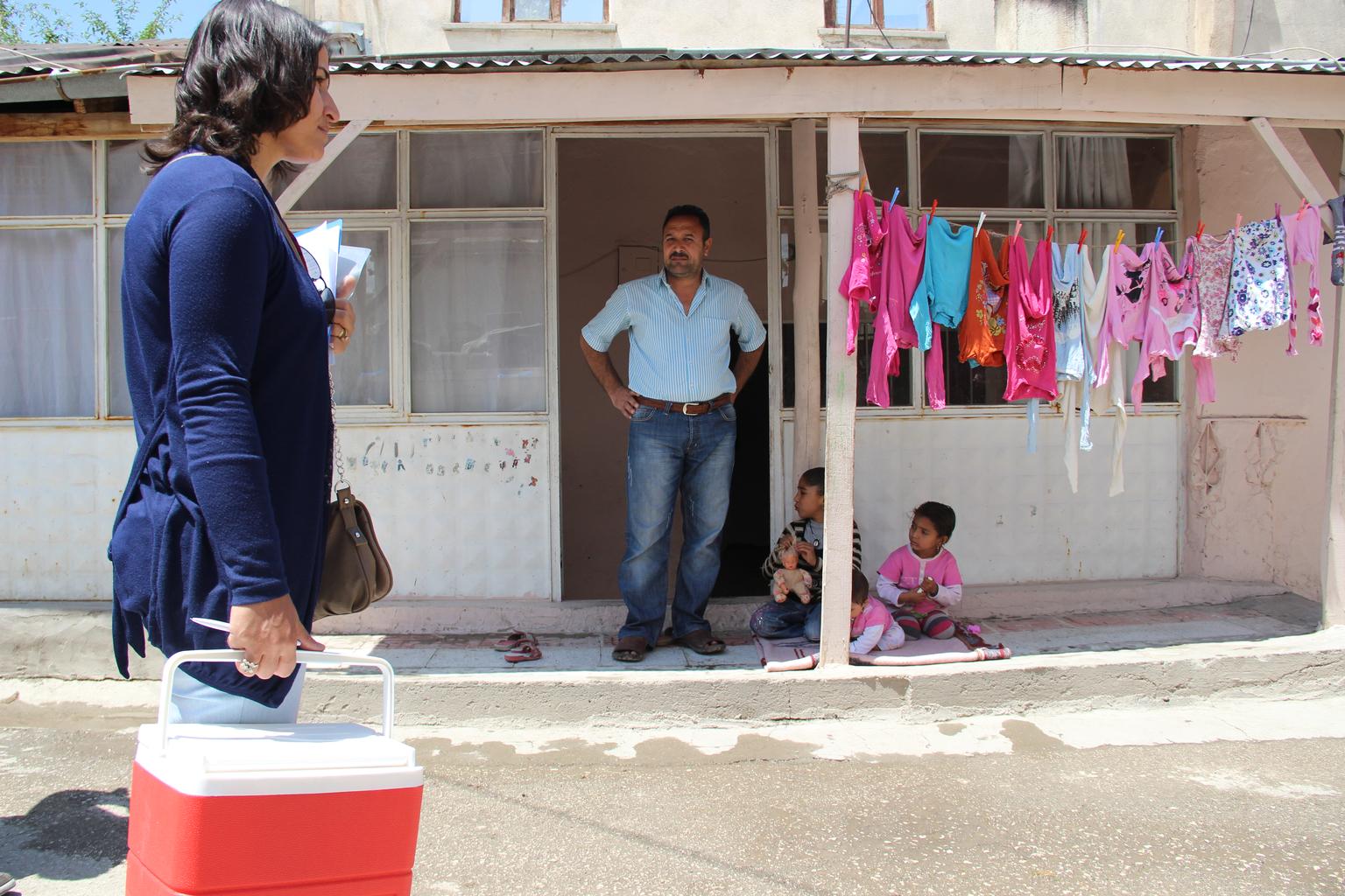 Turkish Ministry of Health workers make house calls to invite parents, like this father of seven who fled violence in Aleppo, Syria, to the local health center, where children can be inoculated against polio. In nearby Syria, where polio outbreaks have oc