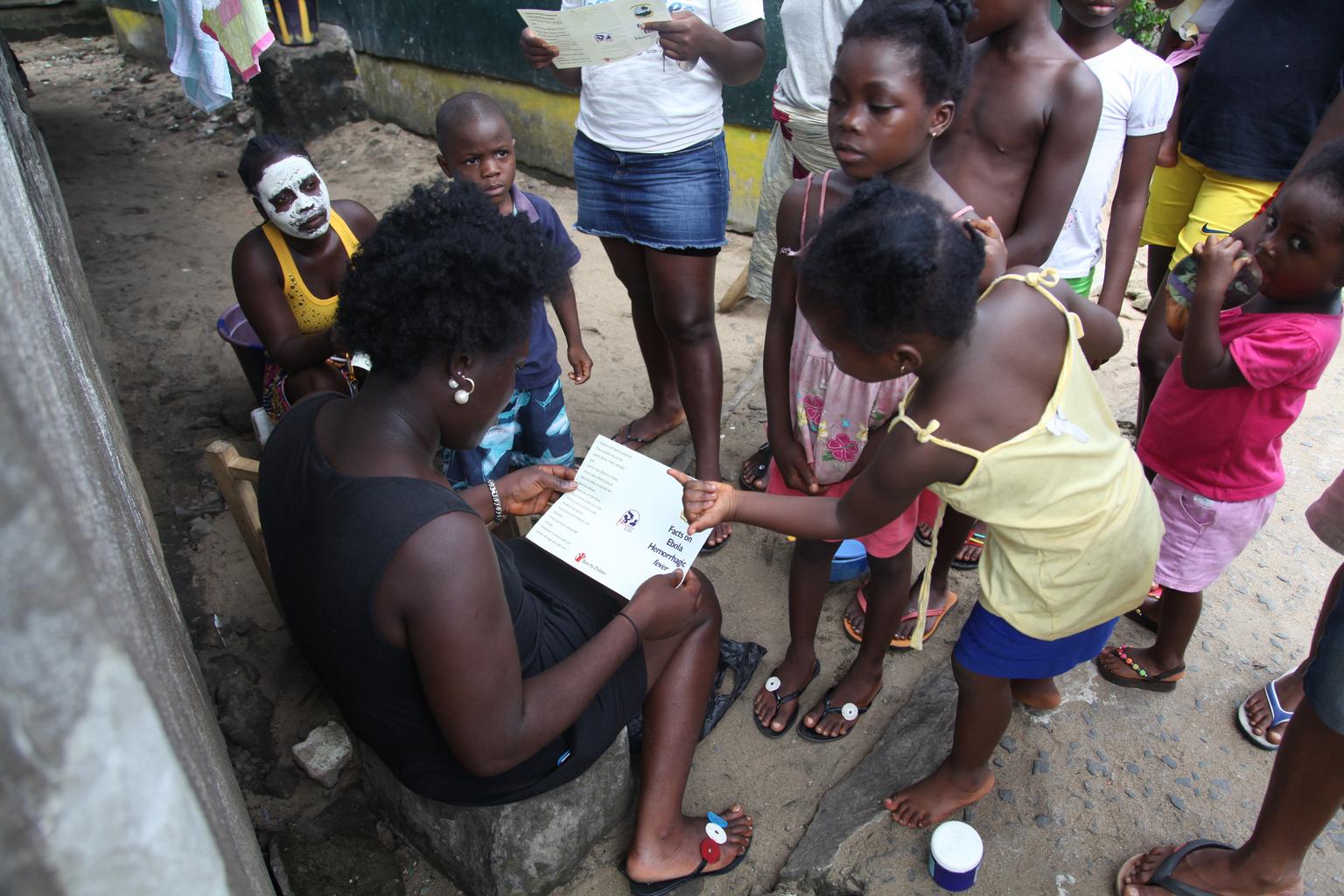 n June 2014 in Liberia, a woman reviews a brochure, distributed by UNICEF, bearing information on the symptoms of Ebola virus disease (EVD) and best practices to help prevent its spread, in New Kru Town, near Monrovia, the capital.