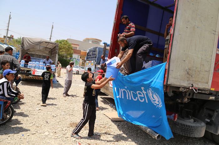 A displaced boy from Anbar province receives a Rapid Response Mechanism (RRM) kit during a distribution in Kalar District, Sulaymaniyah Governorate, Iraq.