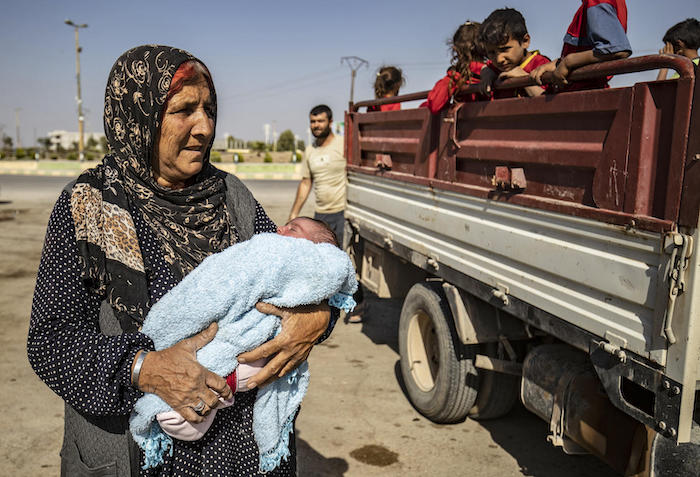 Syrian Arab and Kurdish civilians arrive to Tall Tamr town, in the Syrian northwestern Hasakeh province, after fleeing Turkish bombardment on the northeastern towns along the Turkish border on October 10, 2019.