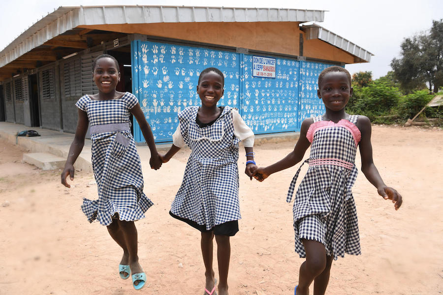 Girls outside their school in central Côte d'Ivoire, constructed with recycled plastic bricks as part of UNICEF's green schools program.