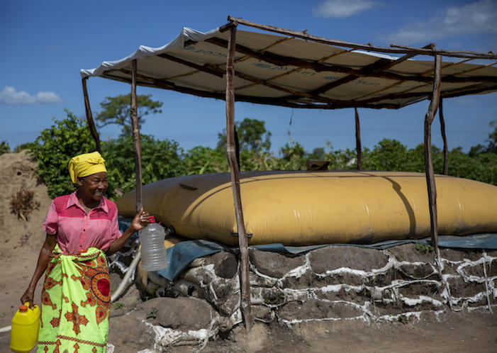 A woman collects water from a water point installed by UNICEF in Guara Guara resettlement camp, Mozambique on March 5, 2020.