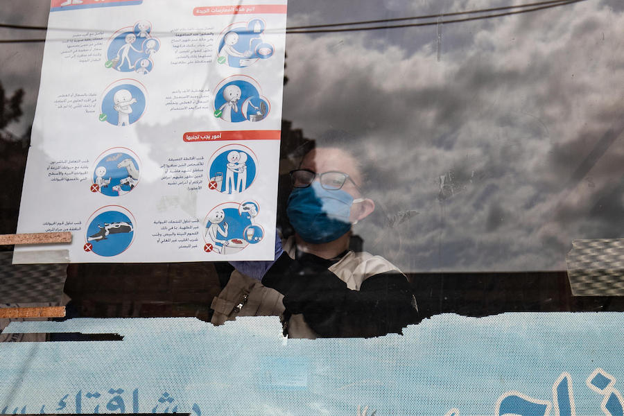 On April 1, 2020, a UNICEF volunteer hangs posters providing important instructions on how to protect against COVID-19 in Qamishly, a city of some 250,000 in northeast Syrian Arab Republic. 