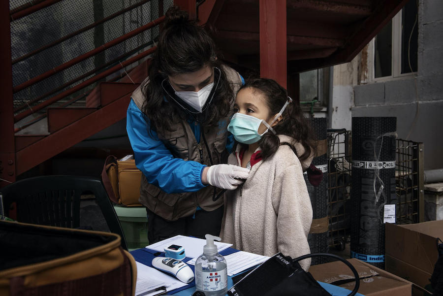 A child receives a medical screening from a member of the INTERSOS/UNICEF medical outreach team deployed at informal settlements in Italy.