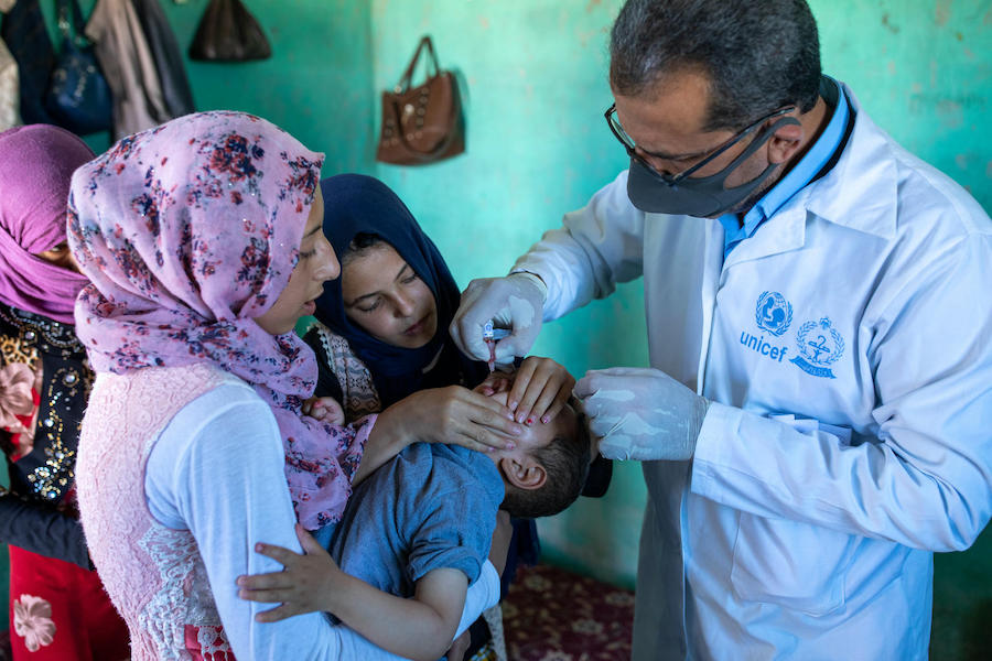 Inside an informal tented settlement in Zarqa governorate, Jordan, a UNICEF health worker immunizes a young boy as part of a joint UNICEF-WHO vaccination campaign.
