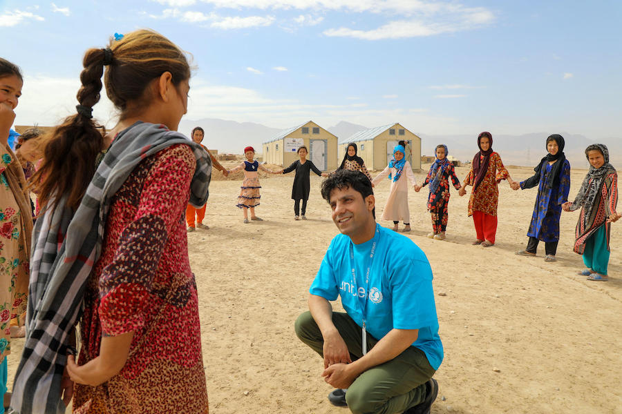 Hashmat Latifi, a UNICEF child protection officer, engages with kids at a Child-Friendly Space at the Ferdousi camp for displaced families in the Nahri Shahi district of Balkh province, northern Afghanistan. 