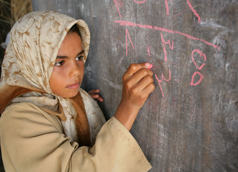 A girl writes on the blackboard during an arithmetic lesson at a local primary school in Yemen 2007.