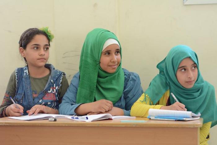 Three girls attend Level 2 of UNICEF’s Curriculum B summer classes at Escandarona school, in the Albayada neighborhood of Homs, central Syria.