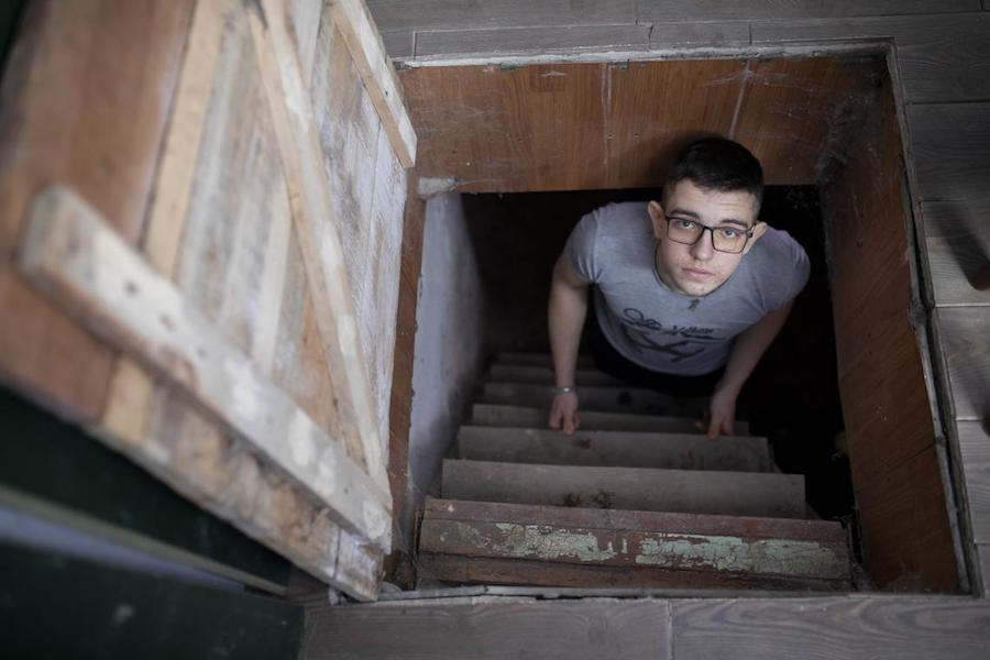 Illia, 16, looks up from the steps into the basement where he and his family sometimes have to shelter in eastern Ukraine.