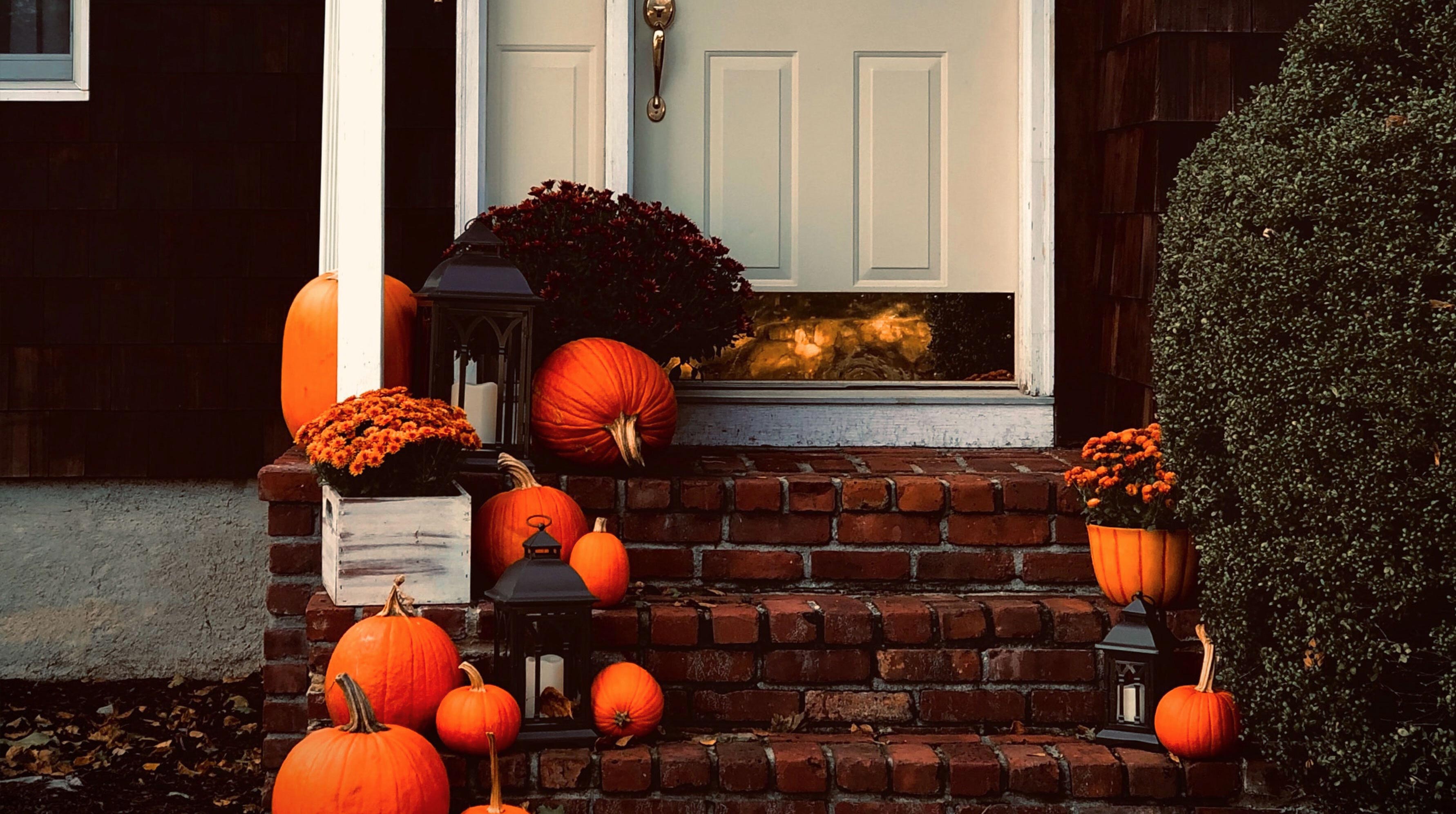 The front door to a house, surrounded by jack-o-lanterns, ready for trick-or-treaters
