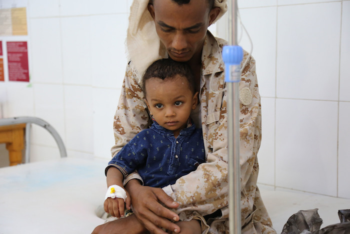 A child suffering from cholera is held by his father as he receives treatment at the Alsadaqah Hospital, Aden, Yemen.