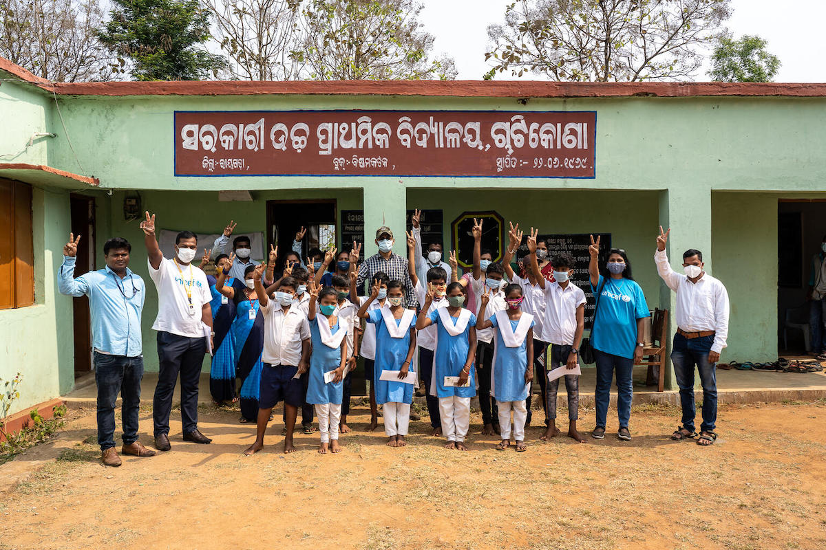 Students celebrate outside a UNICEF-supported community health center in the Rayagada district of Odisha state, India, after receiving their first dose of the COVID-19 vaccine