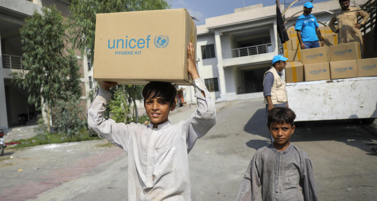 Amjad, 14, carries a box of UNICEF supplies distributed to families impacted by catastrophic flooding in Nowshera district, Khyber Pakhtunkhwa province, Pakistan. 