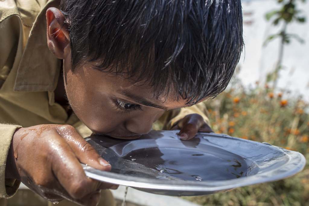 A young boy in Uttar Pradesh, India sips from a bowl of clean water as part of a UNICEF-sponsored, school-based project in 2011 to increase children’s access to healthcare, safe water, good sanitation and proper hygiene.