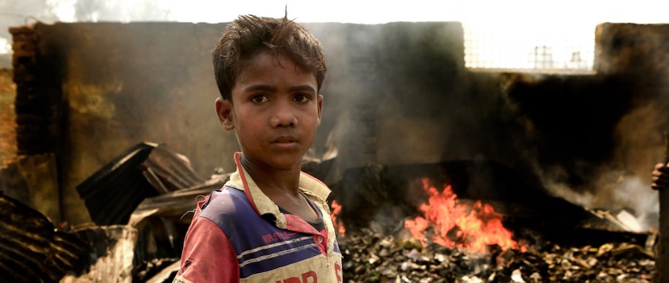 A 10-year-old boy stands amid damage caused by a fire that swept through Rohingya refugee camps in Cox's Bazar, Bangladesh, displacing thousands.