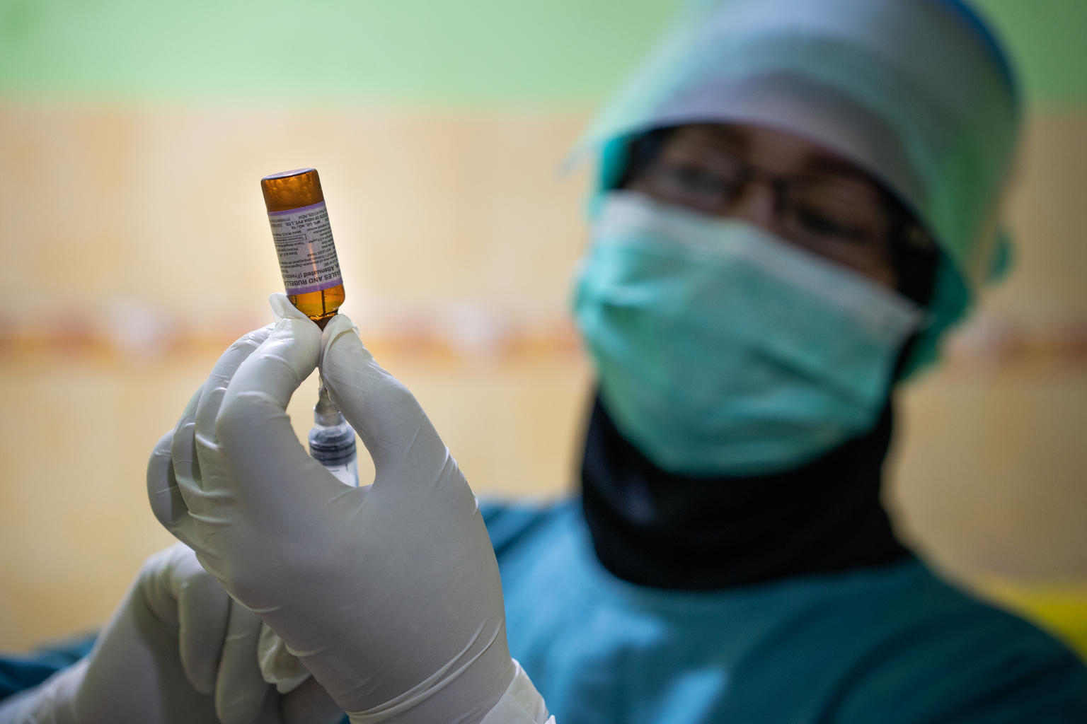 On 16 June 2020, a nurse prepares a syringe for vaccination at the Tegalrejo Community Health Centre in Yogyakarta, Indonesia.