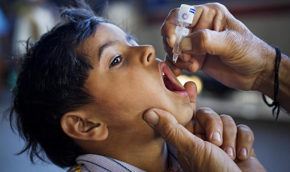 A boy in Pakistan receives the oral polio vaccine. Immunization is key to ending polio globally.