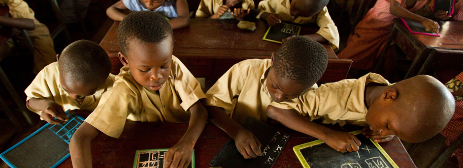 On 6 May, four boys work at a shared desk meant for two students, in an overcrowded classroom in Dixin Centre 2 Primary School in Conakry, the capital of Guinea.