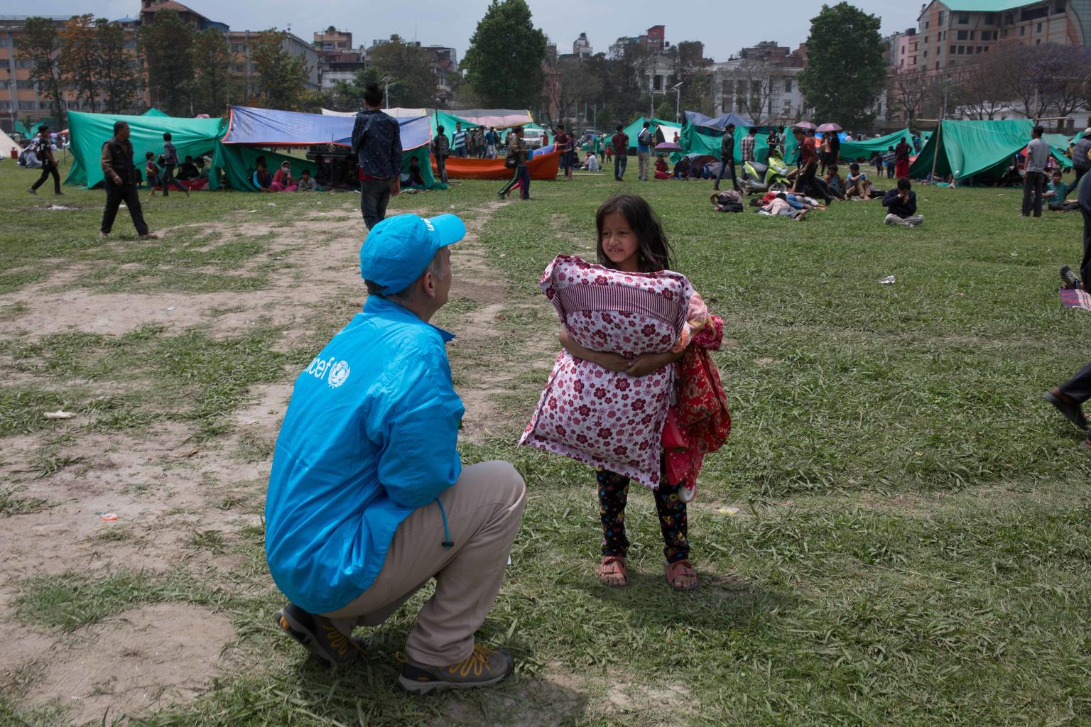 A UNICEF worker speaks to a child seeking temporary shelter in Kathmandu following Nepal's massive earthquake. © UNICEF/NYHQ2015-1007/Nybo
