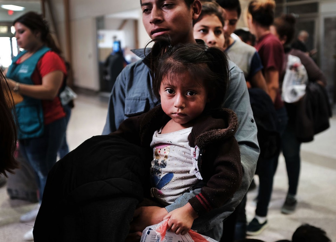 A Guatemalan father and his daughter arrive with dozens of other women, men and children at at bus station following release from Customs and Border Protection in McAllen, Texas. 