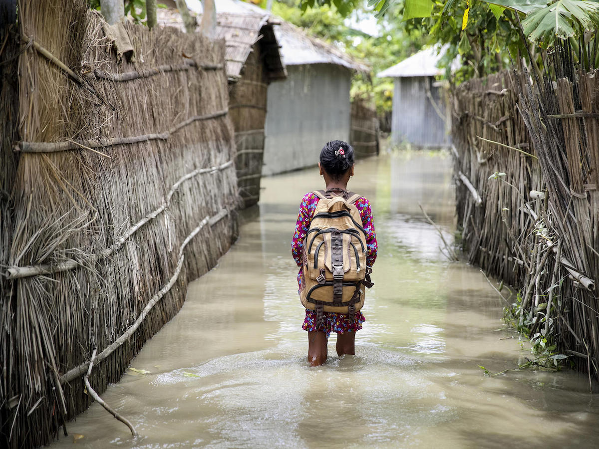 A child wades through flood water on her way to school in the Kurigram district of northern Bangladesh during monsoon season, August 2016.