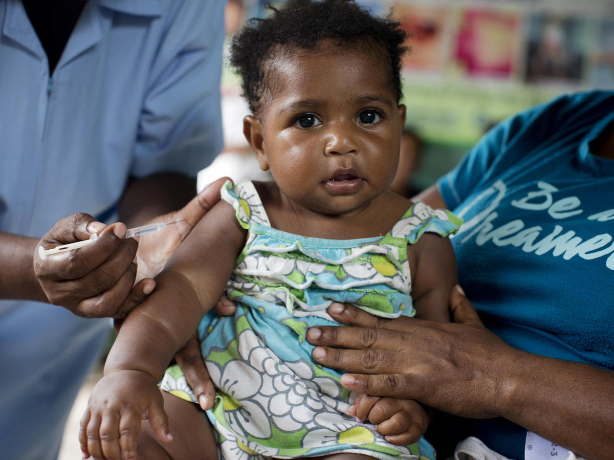 A UNICEF-supported health worker vaccinates a child against measles, mumps and rubella (MMR) at the 9 Mile Health Clinic in Port Moresby, Papua New Guinea in March 2019. 