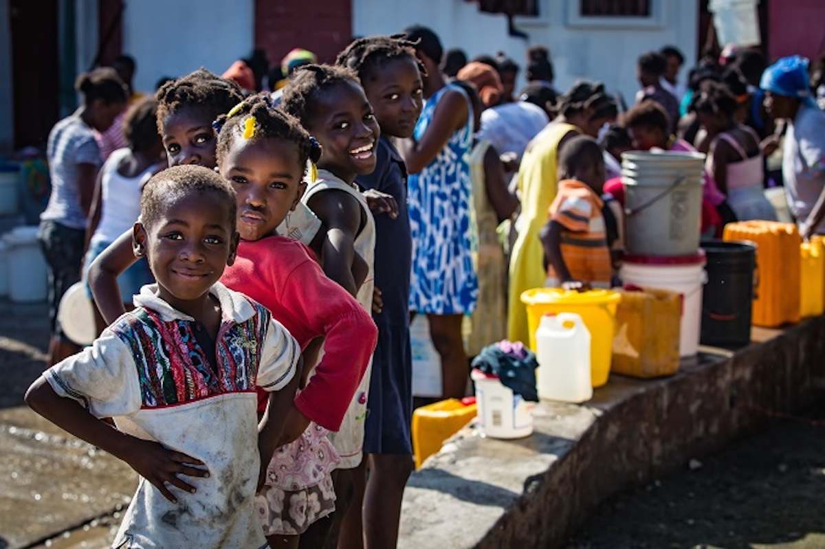 Kids in Haiti collect safe water at a UNICEF distribution point following Hurricane Matthew, which disrupted supplies and put families at risk of cholera and other water-borne diseases.
