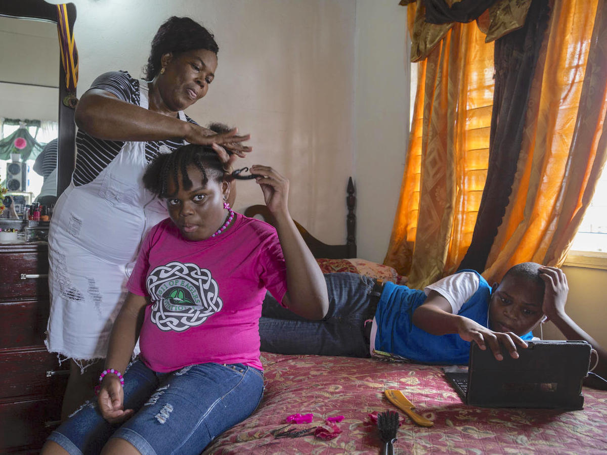Corine Gerald and her children Jerrene, 11, and James Jr., 13, in their rental house in Antigua. The family was displaced from their home in Barbuda by Hurricane Irma in 2017. 